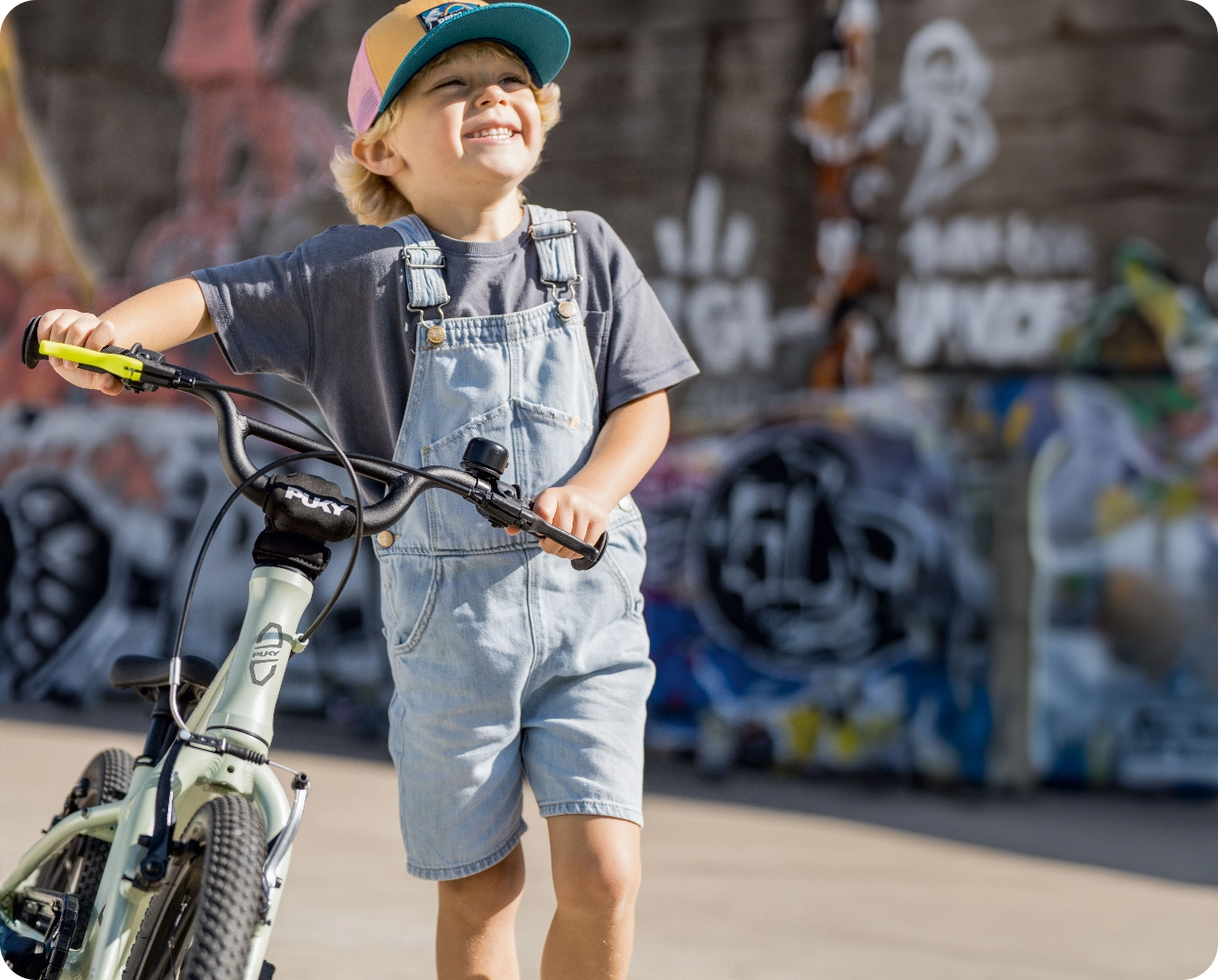 Dreng med hjelm på PUKY børnecykel i skatepark